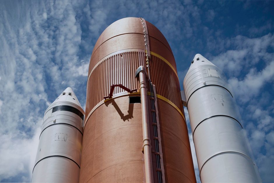 Rocket boosters against a bright sky, showcasing aerospace technology.