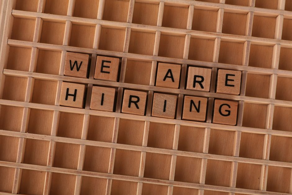 Wooden tiles on a board forming the phrase 'We Are Hiring'.