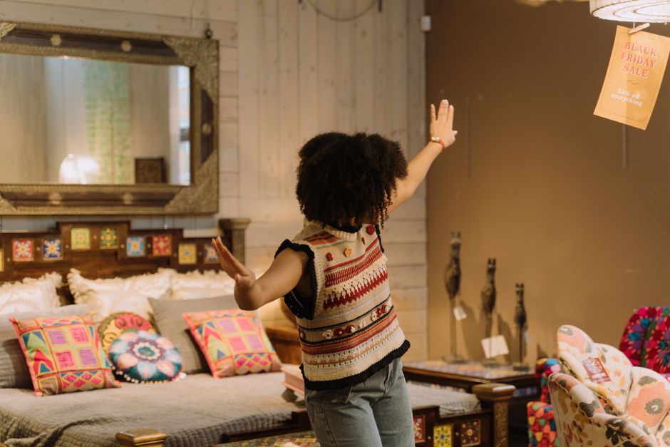 A shopper moves through a home-decor retail setting, a concrete reminder that discretionary demand must be earned.