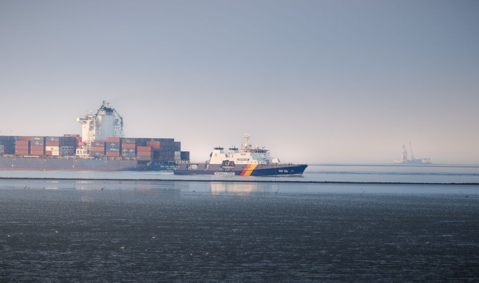 Coast Guard and container ships sailing near a strategic shipping route