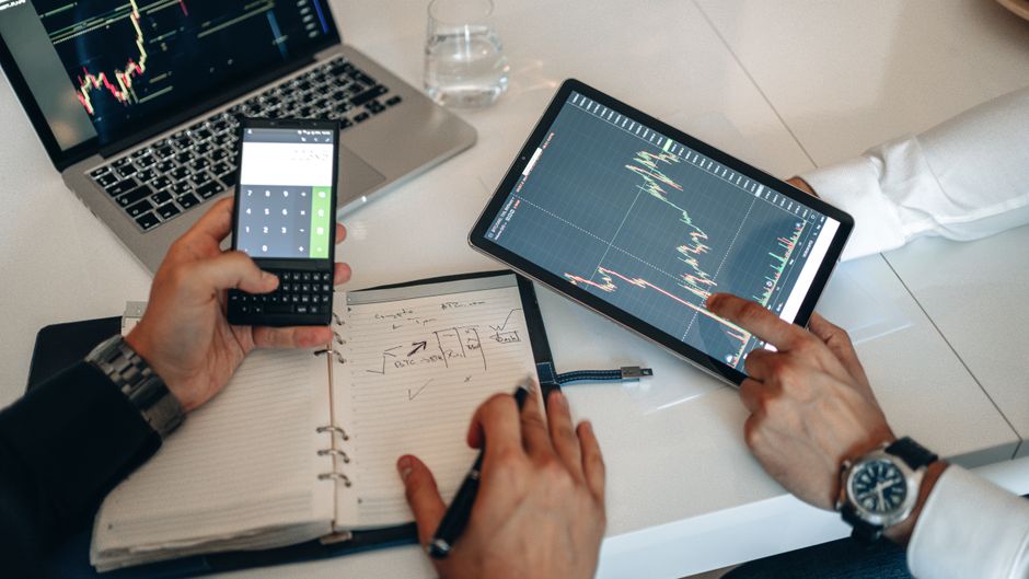 Market participants analyzing financial data and technology exposure on digital devices