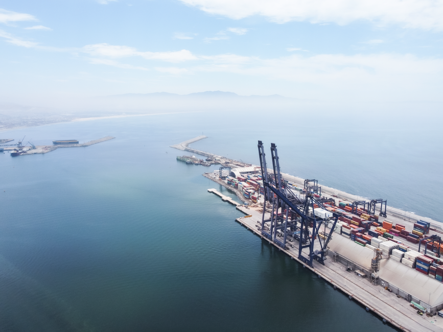 Aerial view of a busy container shipping port with cranes and cargo ships