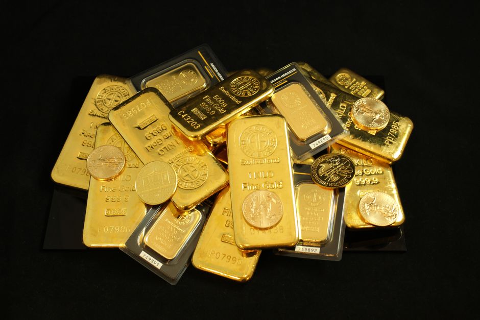Gold bars and coins on a dark surface
