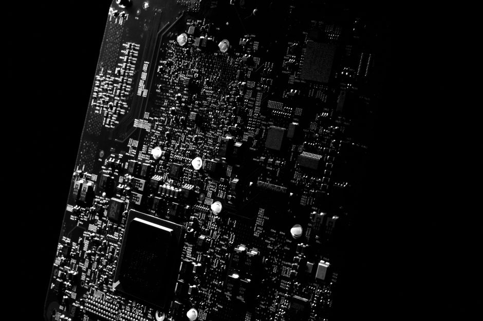 Detailed black and white close-up of a circuit board showcasing modern technology, representing the semiconductor and memory chip rally at the heart of this week's split-level tape.