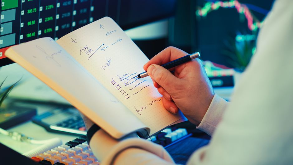 Trader reviewing electronic market data as new listings compete for capital and liquidity.