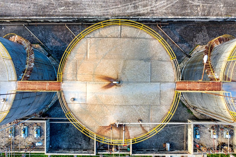 Industrial petroleum storage tanks connected by pipelines at a fuel terminal, representing crude oil supply and energy infrastructure.