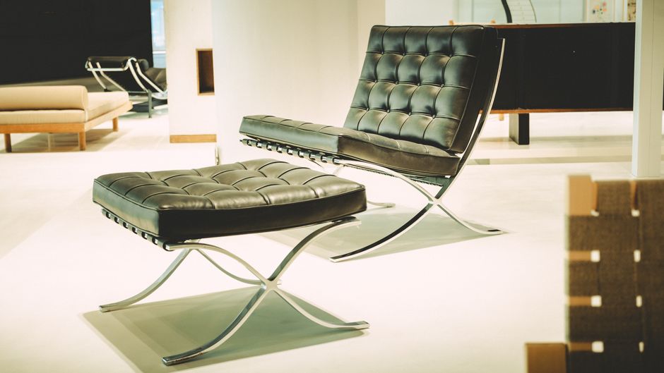 A black leather lounge chair with ottoman in a modern interior setting.