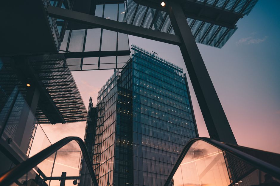 A modern skyscraper with a glass facade at sunset, representing the institutional architecture of financial markets.