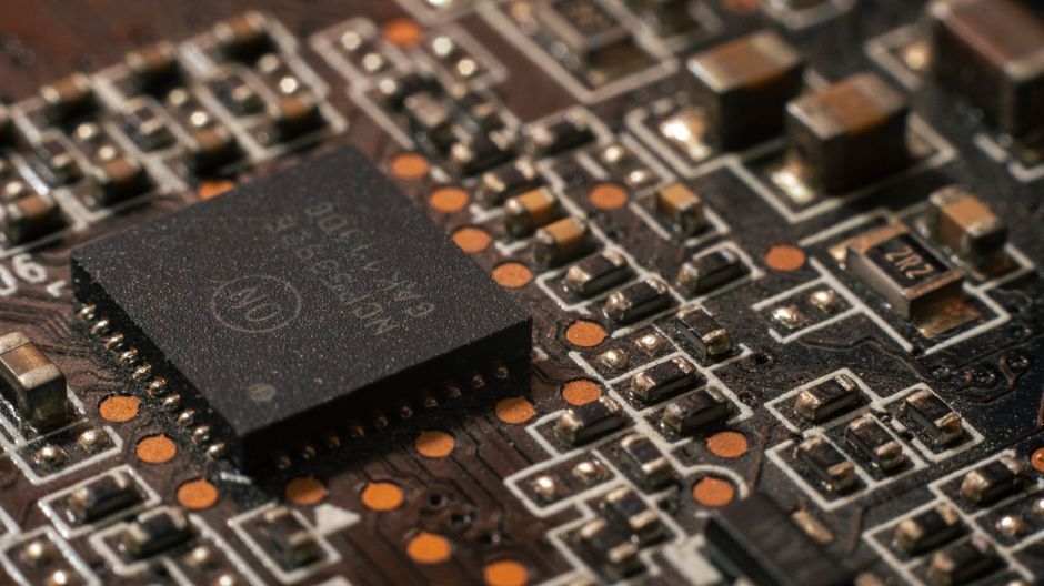 Close-up of a green circuit board with electronic components and microchips