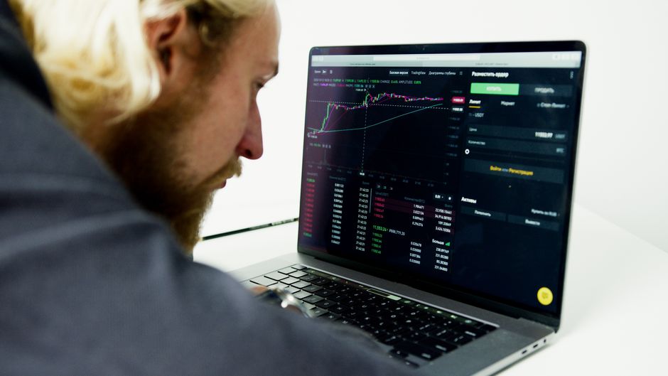 Financial analyst reviewing market data on a laptop before a major jobs report.