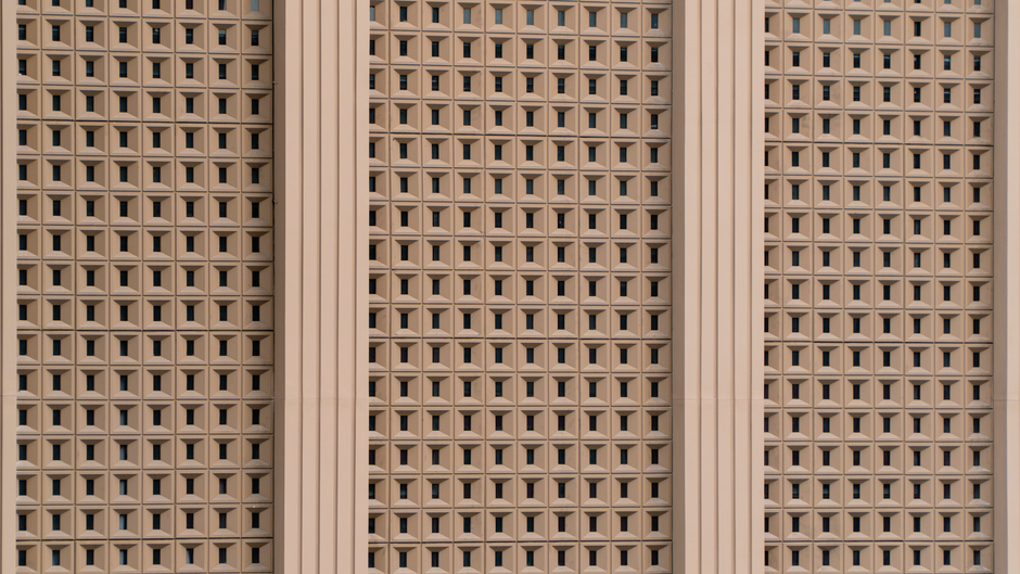 Close-up of a building facade with repeating geometric patterns, representing the institutional backdrop for interest-rate policy.