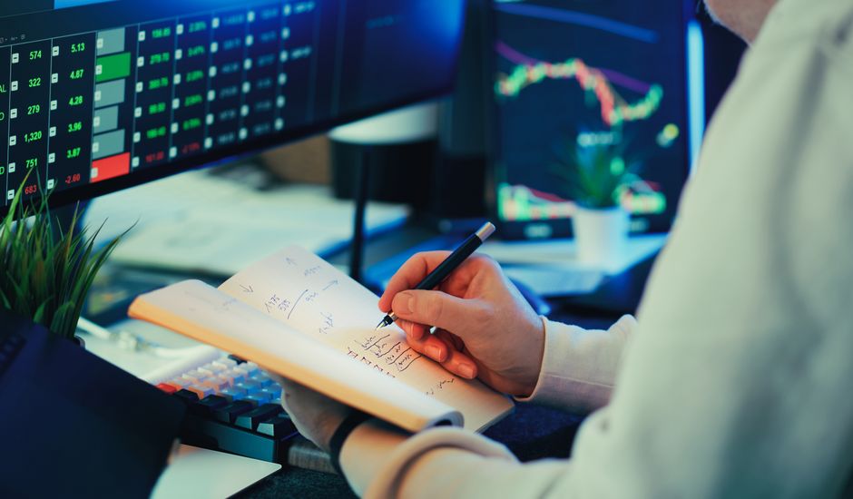 A financial analyst reviews market data on multiple screens while evaluating new issuance and liquidity.