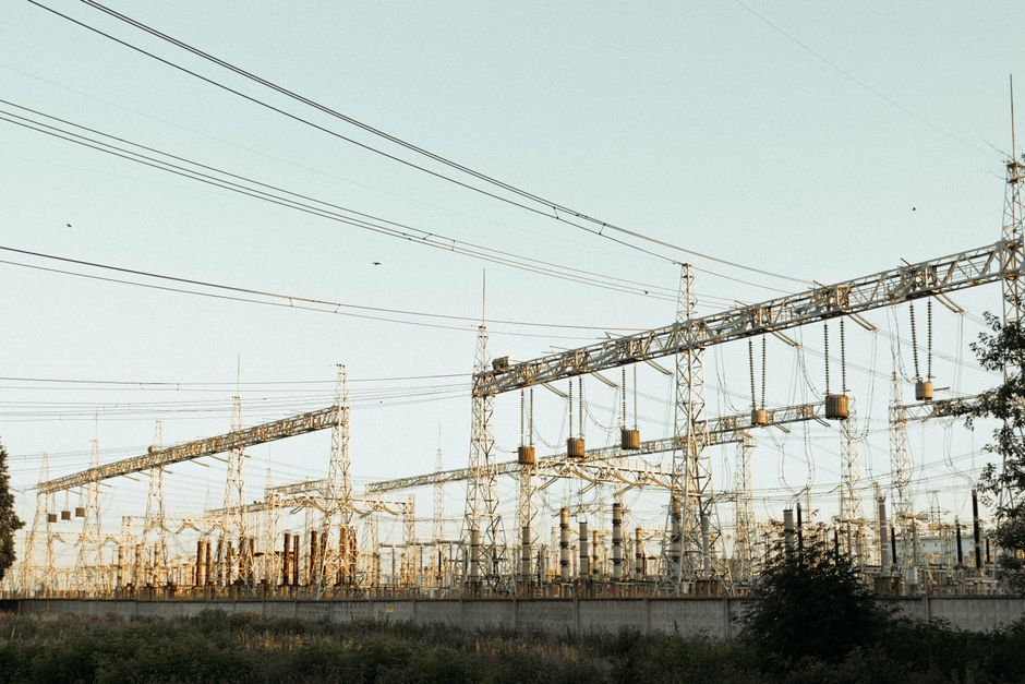 Power lines and an electrical substation represent the grid infrastructure required for AI data-center expansion.