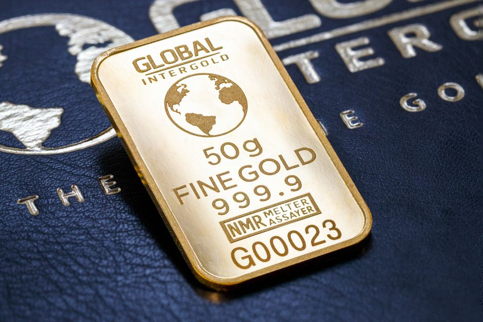 A gold bar labeled Global Intergold resting on a textured surface