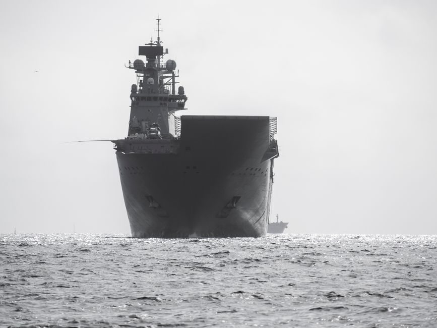An aircraft carrier navigates through open waters