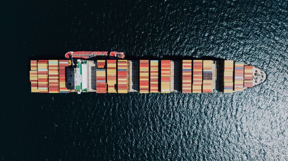 Aerial view of a container ship moving along a maritime supply route