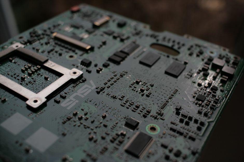 Close-up of an electronic circuit board with intricate components, representing semiconductor manufacturing and AI chip infrastructure