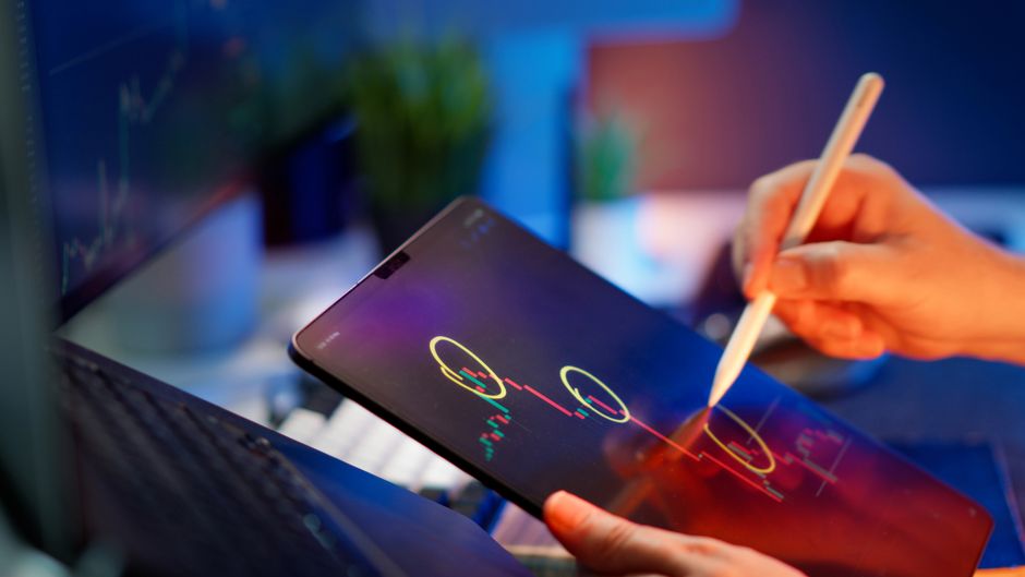 A tablet displays digital market and analytics data relevant to technology-led growth.