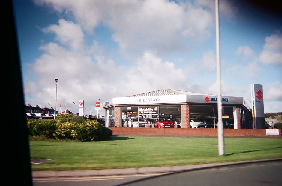 A car dealership building representing the consumer-demand side of the market’s resilience debate.