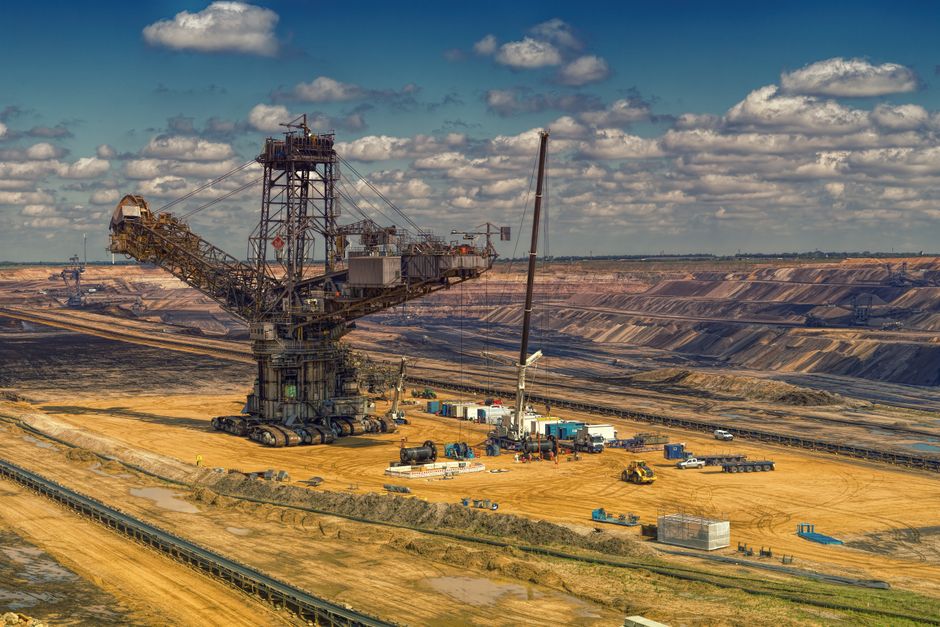 Aerial view of heavy machinery operating in a vast open-pit mine.