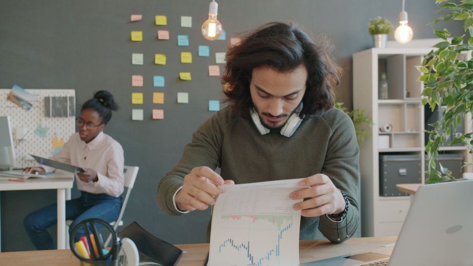 Two colleagues review financial documents as companies prepare for public-market decisions.