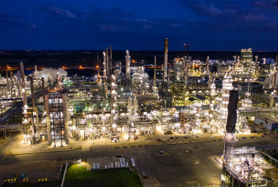 Aerial view of a brightly lit industrial refinery at night