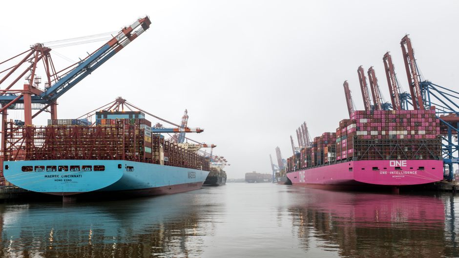 Container ships at a major port as shipping disruption raises logistics and energy-market risk.