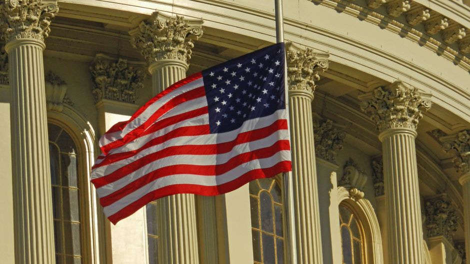 US flag flying on a pole outside the Capitol building in Washington DC