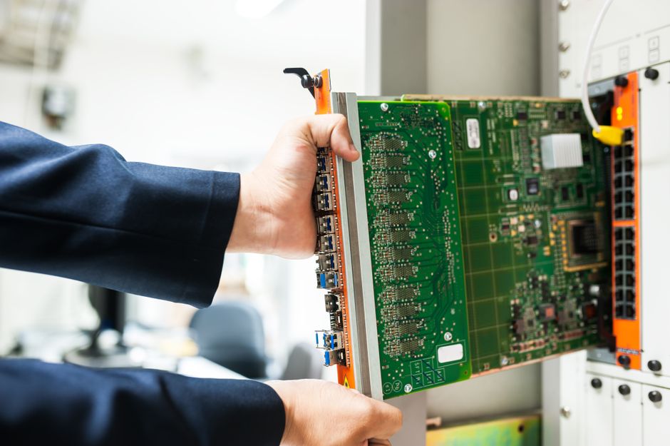 Technician inspecting high-density computing hardware as AI infrastructure faces a financing test.