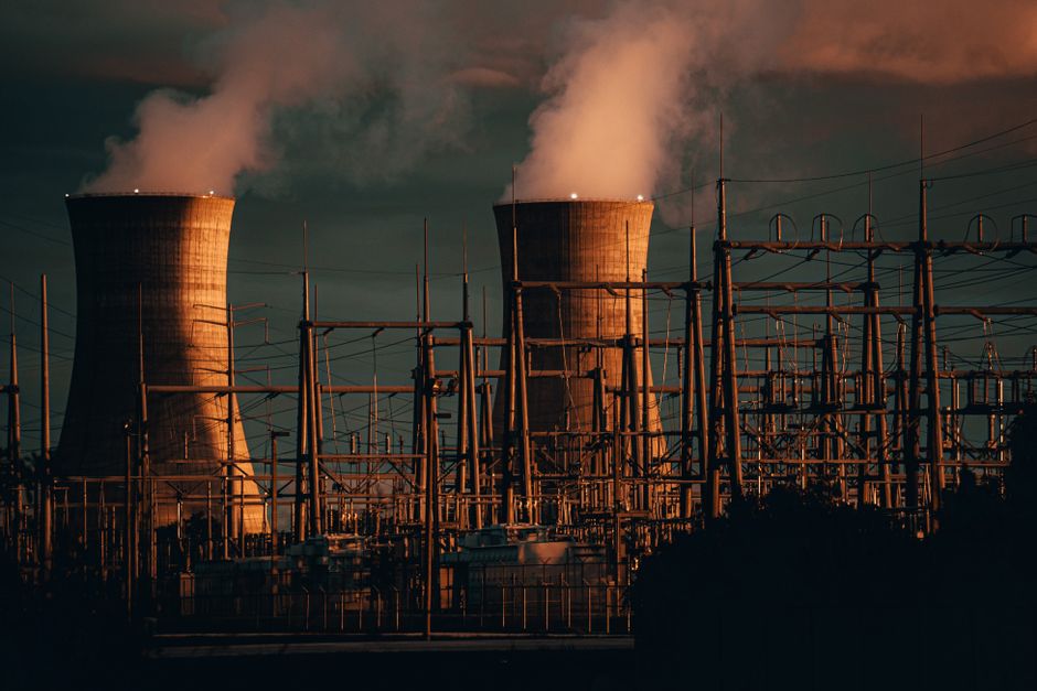 Cooling towers of a power plant emitting steam at sunset