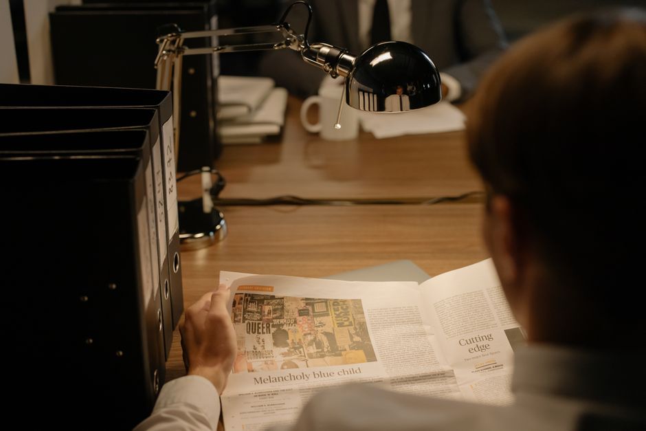 Person reviewing a newspaper at a desk, reflecting the market’s focus on oil, rates, and geopolitical risk.