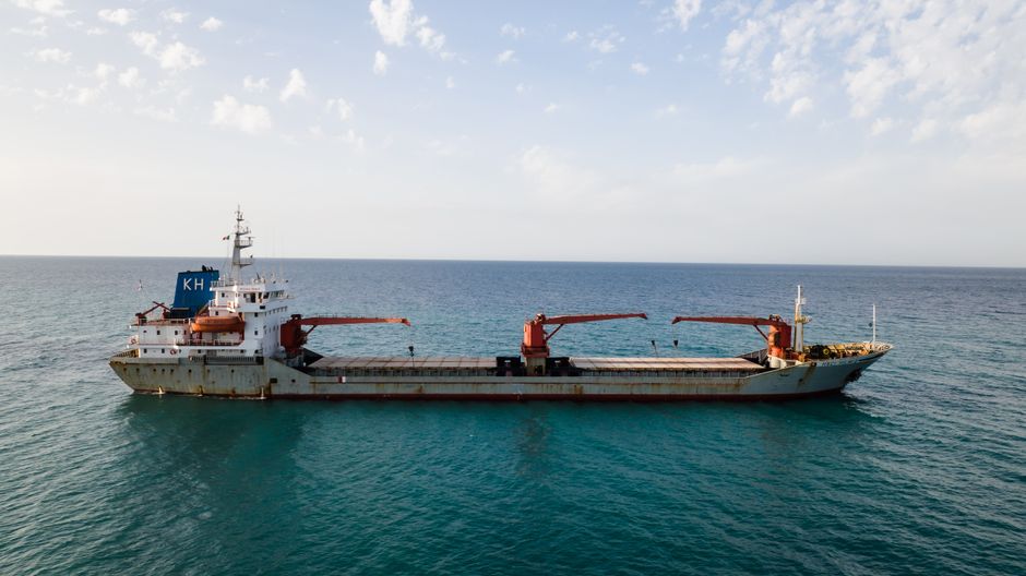 Aerial view of a cargo ship sailing through open water on a strategic maritime route.
