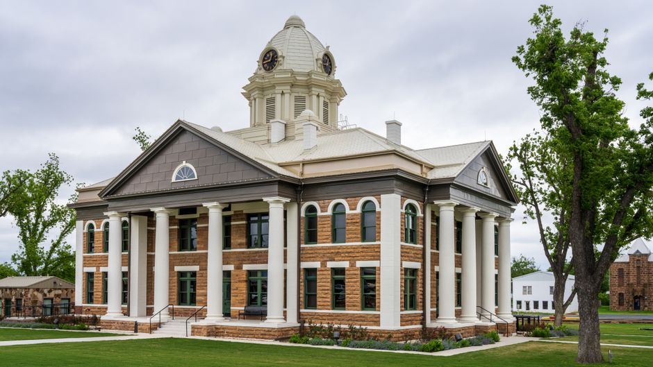 Historic Mason County Courthouse with classic pillars against a cloudy sky