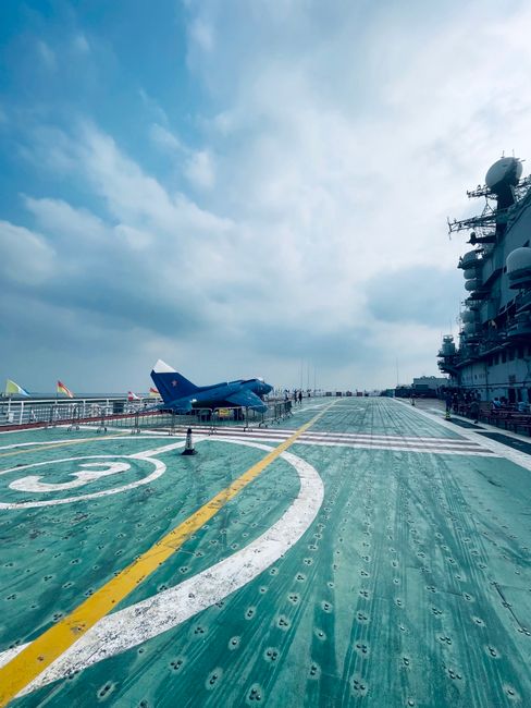 Military aircraft on an aircraft carrier deck at sea