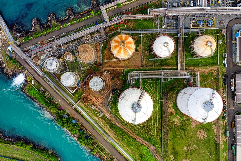 Aerial view of an industrial complex with storage tanks near a river