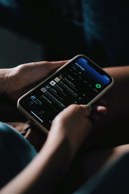 Person holding a smartphone displaying an app on screen