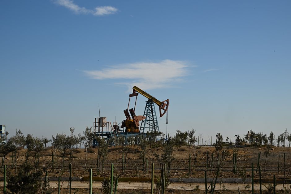 Oil pump jack in a dry landscape with clear sky