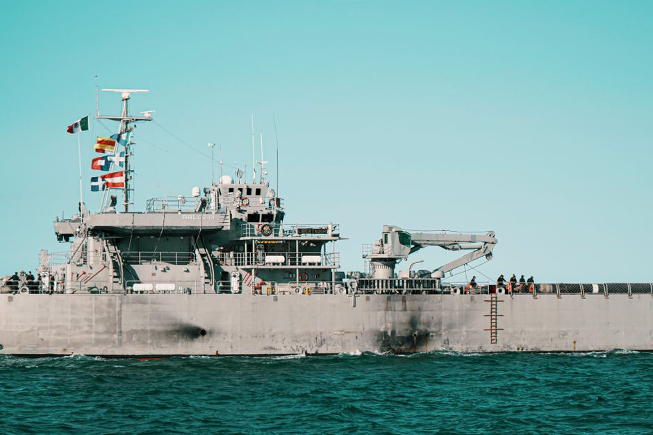A naval warship sailing on open ocean under cloudy skies, illustrating maritime blockade and chokepoint security risks.