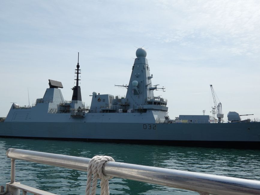 A modern naval destroyer warship docked in harbor