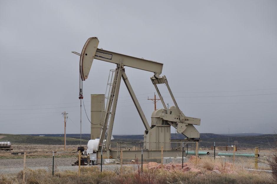 Oil pumpjack in a barren landscape under overcast skies