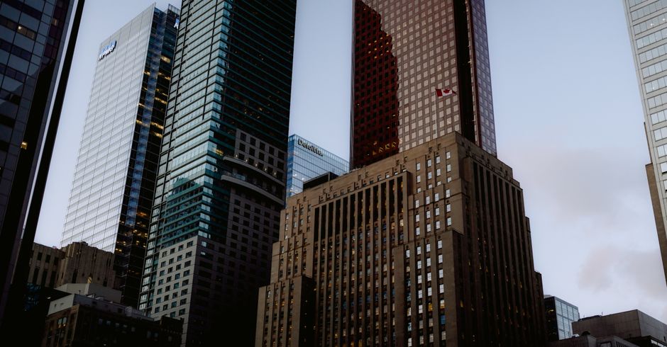Contemporary multistory buildings with creative design in a modern city center, seen at evening against a blue sky.