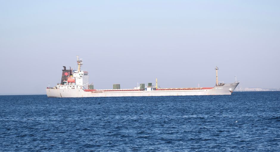 Freighter ship traveling through open water, representing commercial shipping through a strategic energy corridor.