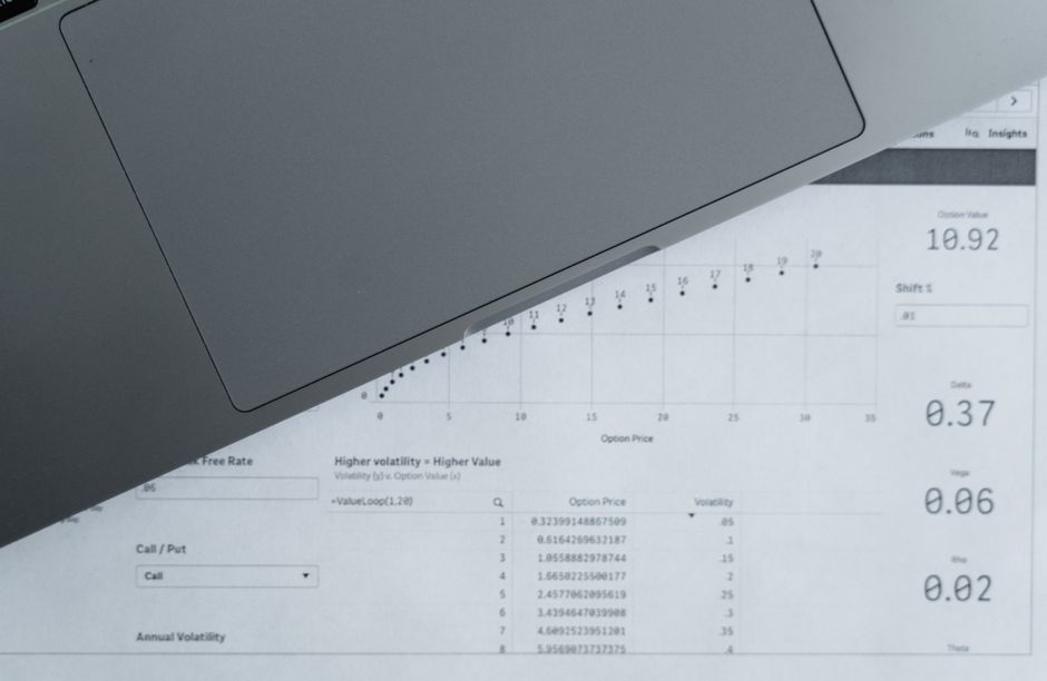 Economic data sheets and a laptop representing analysis of employment, inflation, and interest rates.