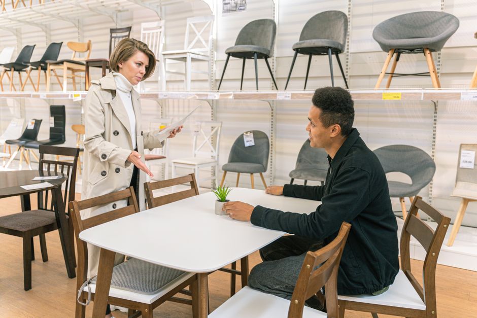 A customer discusses a furniture purchase in a showroom