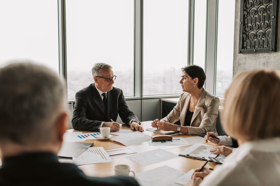 Business professionals discussing strategy as companies evaluate public-market capital and liquidity.