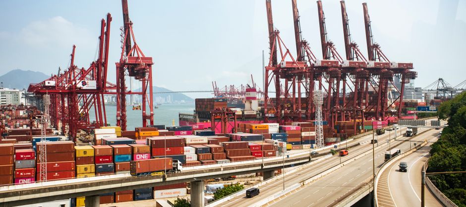 Container cranes and stacked cargo boxes at a major shipping port