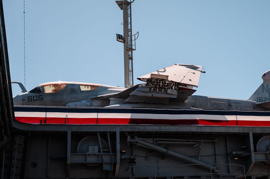 Close-up of a military aircraft on display against a clear blue sky in San Diego, CA.