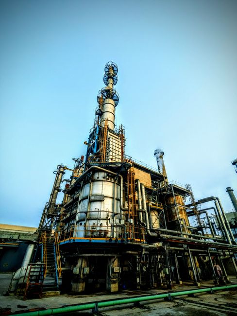 Industrial refinery tower under clear skies