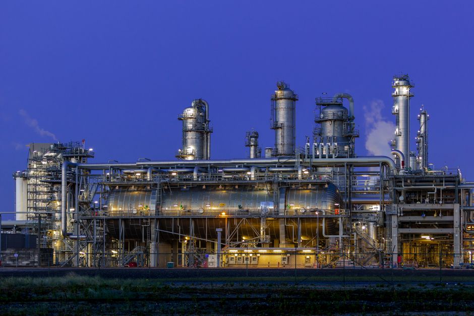 An industrial petrochemical facility illuminated at dusk