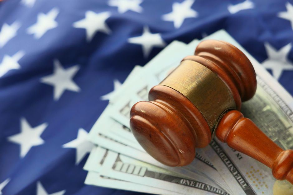 Gavel on US dollar bills with American flag backdrop